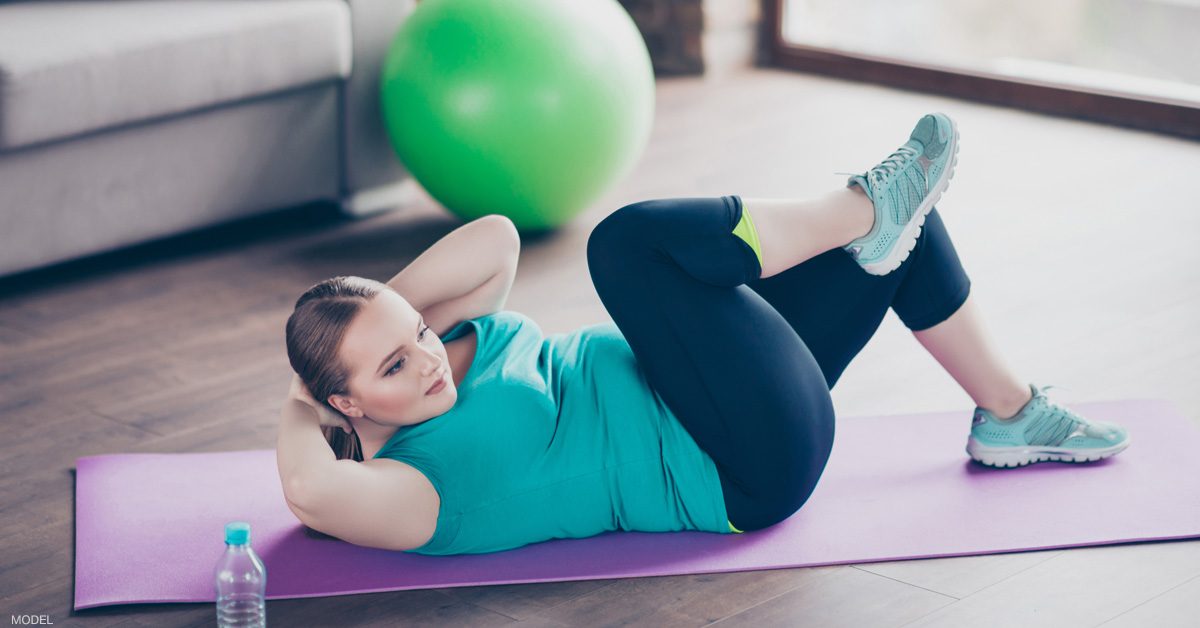 Woman doing sit ups and trying to lose belly pooch (model)