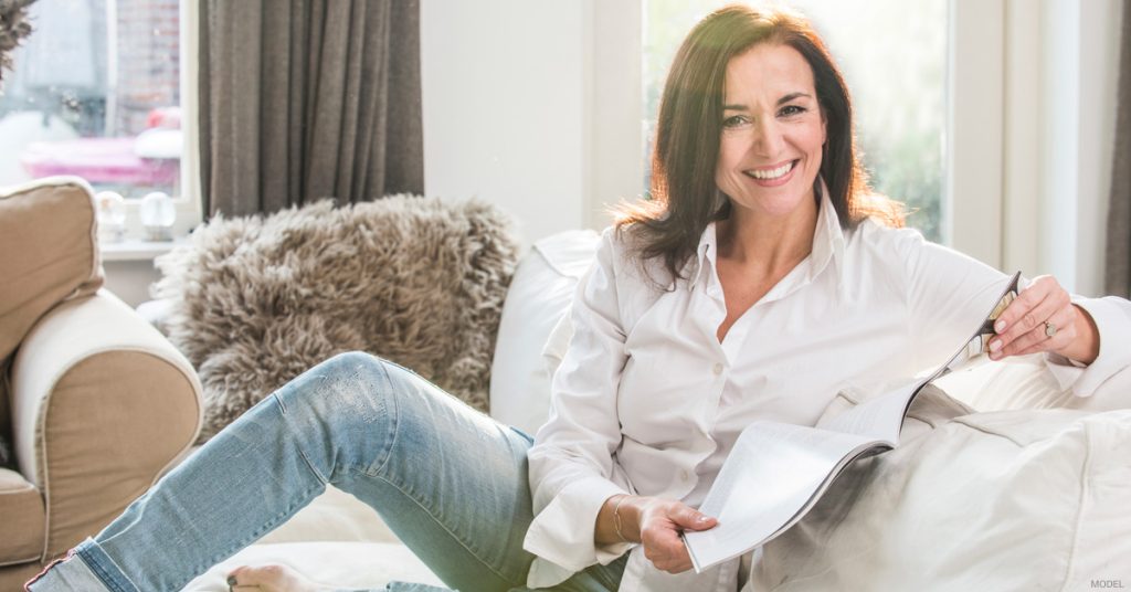 Woman relaxing on couch during liposuction recovery