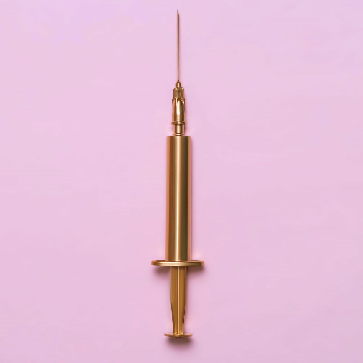 Golden syringe on a pink background. Medical item. Minimalism concept.