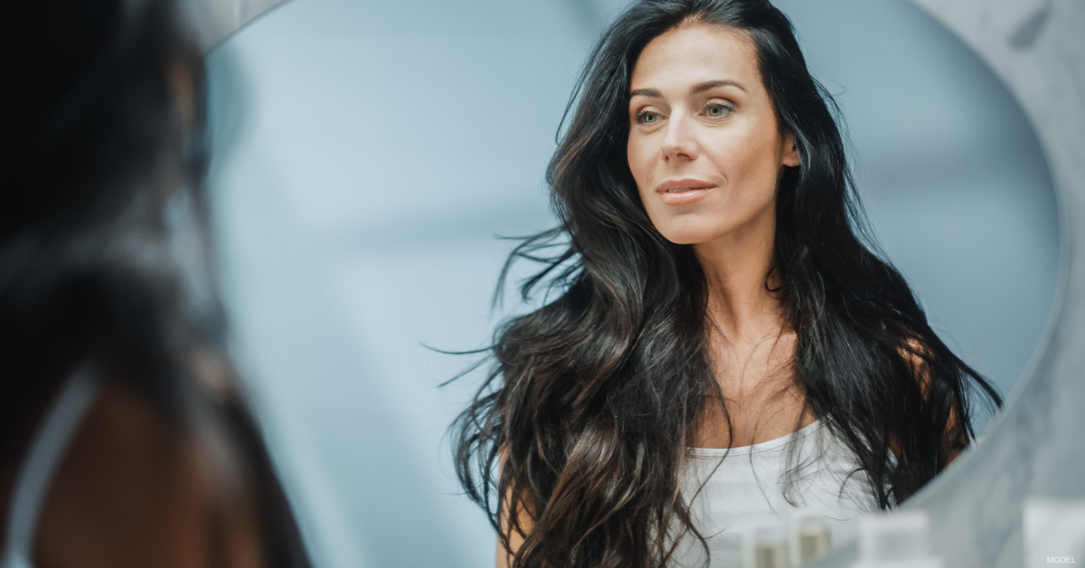 Mature woman admiring her reflection in the mirror (model)