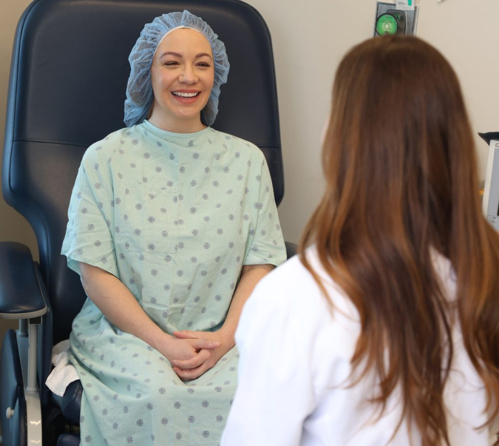 South Bay Plastic Surgeon provider meeting with patient in hospital gown