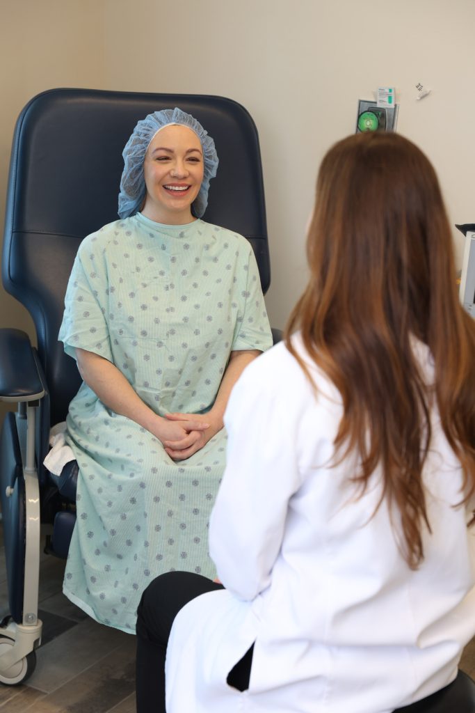 South Bay Plastic Surgeon provider meeting with patient in hospital gown
