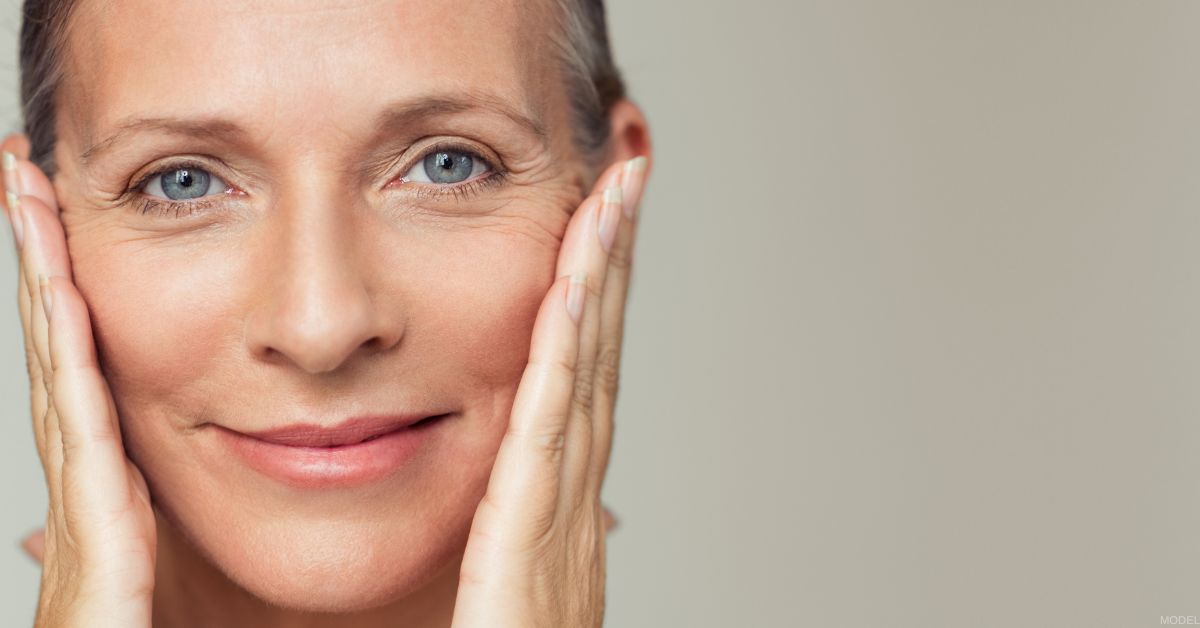 Mature woman with her hands on her face (model)