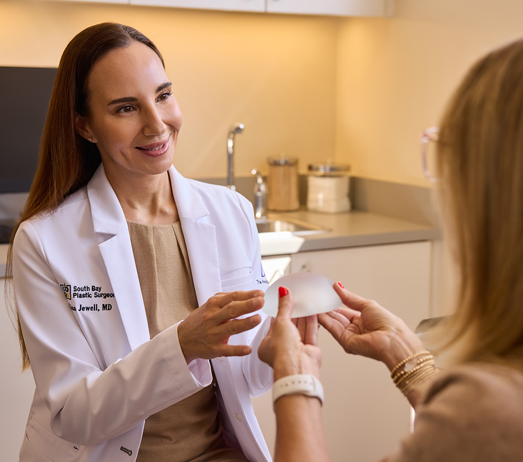 Dr. Lisa Jewell showing a breast implant to a patient during a consultation.
