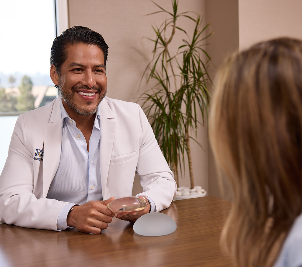 Dr. Juan Rendon discussing breast implant options with a patient during an office consultation